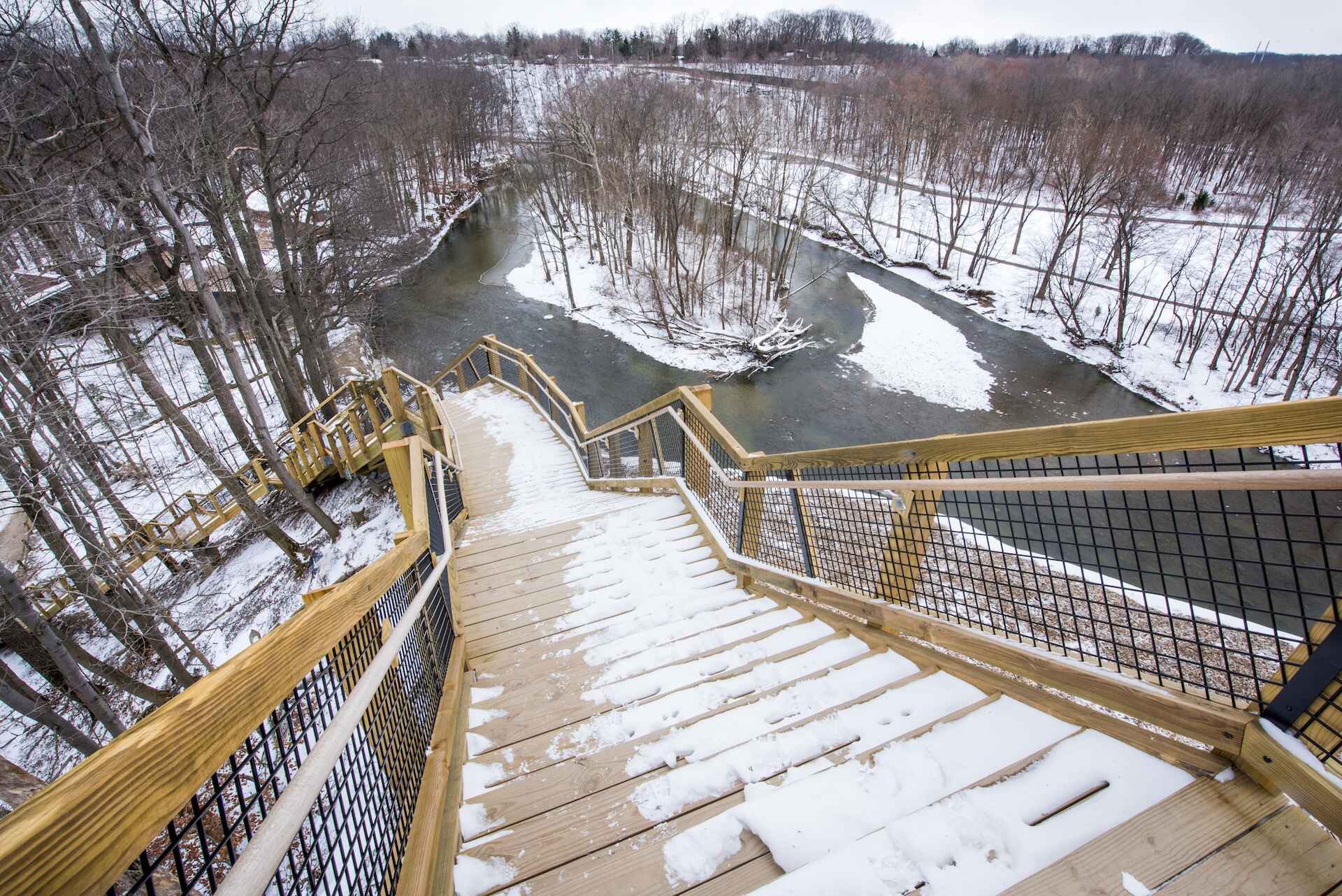 A snowy staircase along a frozen river