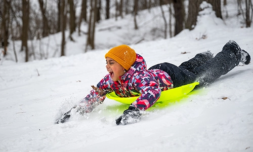Child sledding downhill