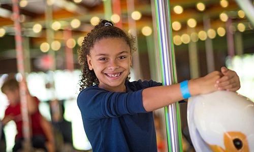 Child on Circle of Wildlife Carousel