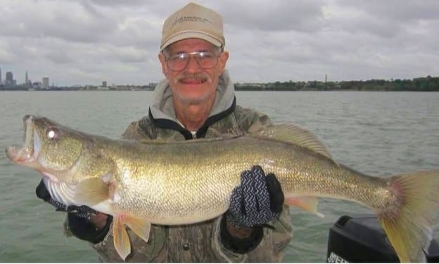 Man holding walleye fish along Lake Erie