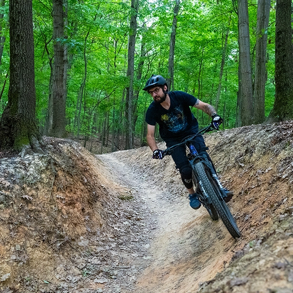 Photo of man riding a mountain bike through park reservation