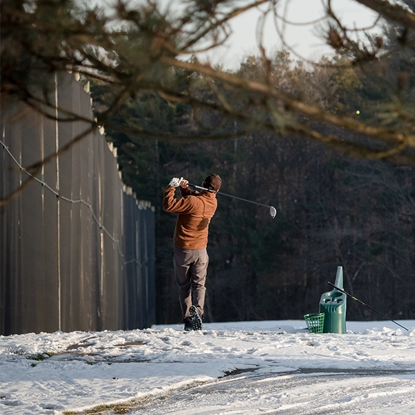 Man practicing at Driving range during winter