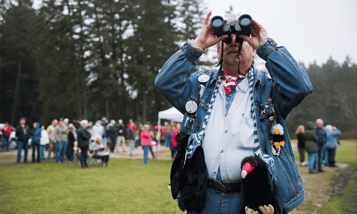 Man looking up at the sky with binoculars 