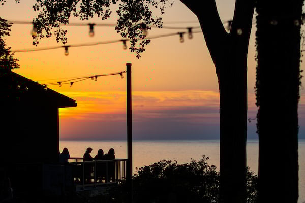 Sunset behind people sitting on a balcony