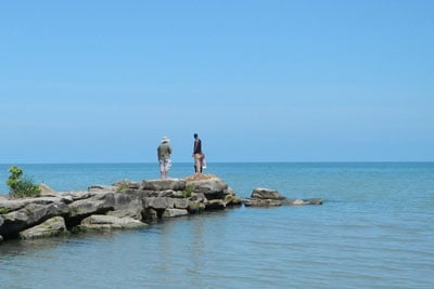People standing on a rock pier in the water