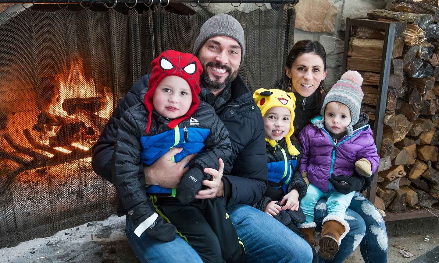 Family posing for a photo in front of a fireplace