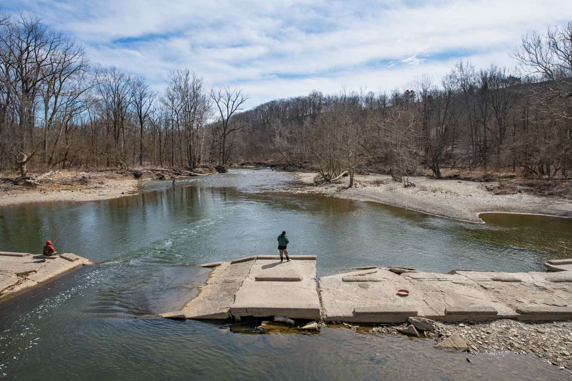 A person standing on rocks in the water