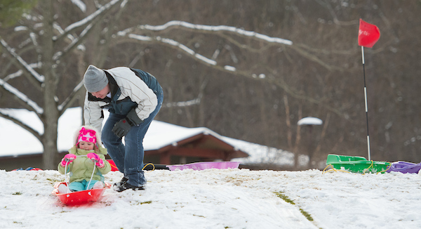 Girl sledding down a hill