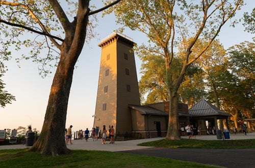 trees in front of a building with a clock tower on top, a digital rendering inspired by Fitz Henry Lane, instagram contest winner, hudson river school, lookout tower, observation deck, upon a peak in darien